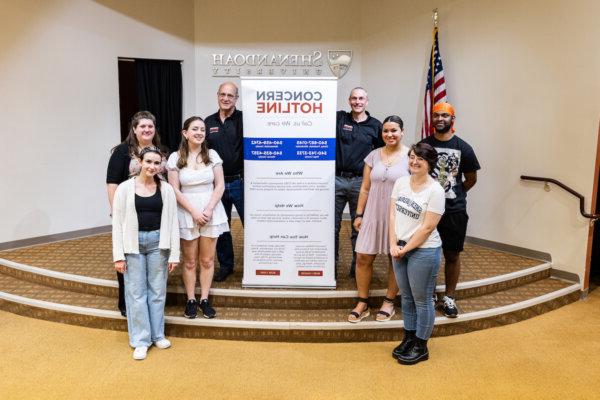 Members of Shenandoah's Clinical Helping Skills psychology course pose for a photograph with a banner for Concern Hotline